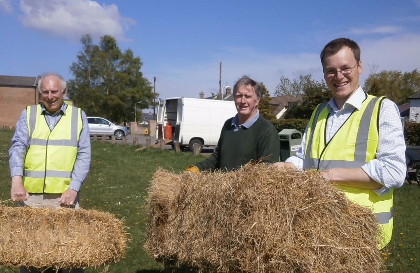 Michael Tomlinson, Peter Webb and Ian Maitland carrying bales of hay
